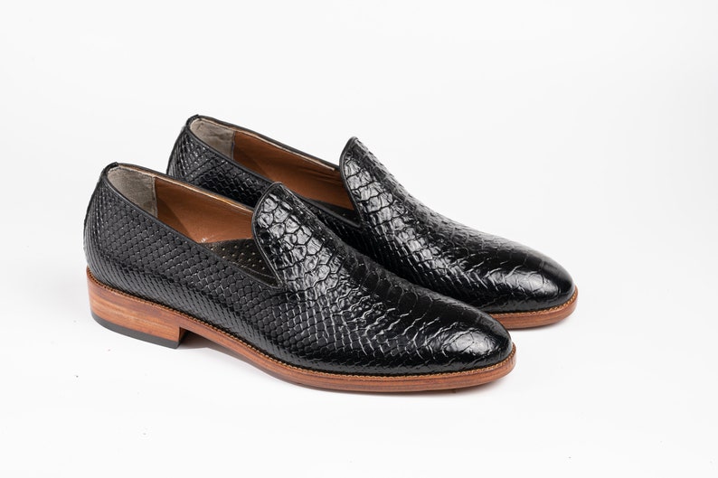 "Black Exotic Loafers: Handcrafted from premium leather. Wholecut Loafers: Custom-made with exotic fish leather. Formal Shoes: Featuring a vegetable-tanned sole and cushioned footbed. Luxury Footwear: Bespoke design for a personalized fit. Breathable Lining, Durable Construction: Stylish and functional."