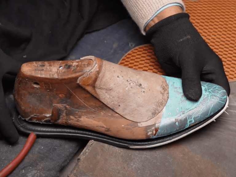 Handsole's expert Bottoman crafting a leather insole onto a shoe last.